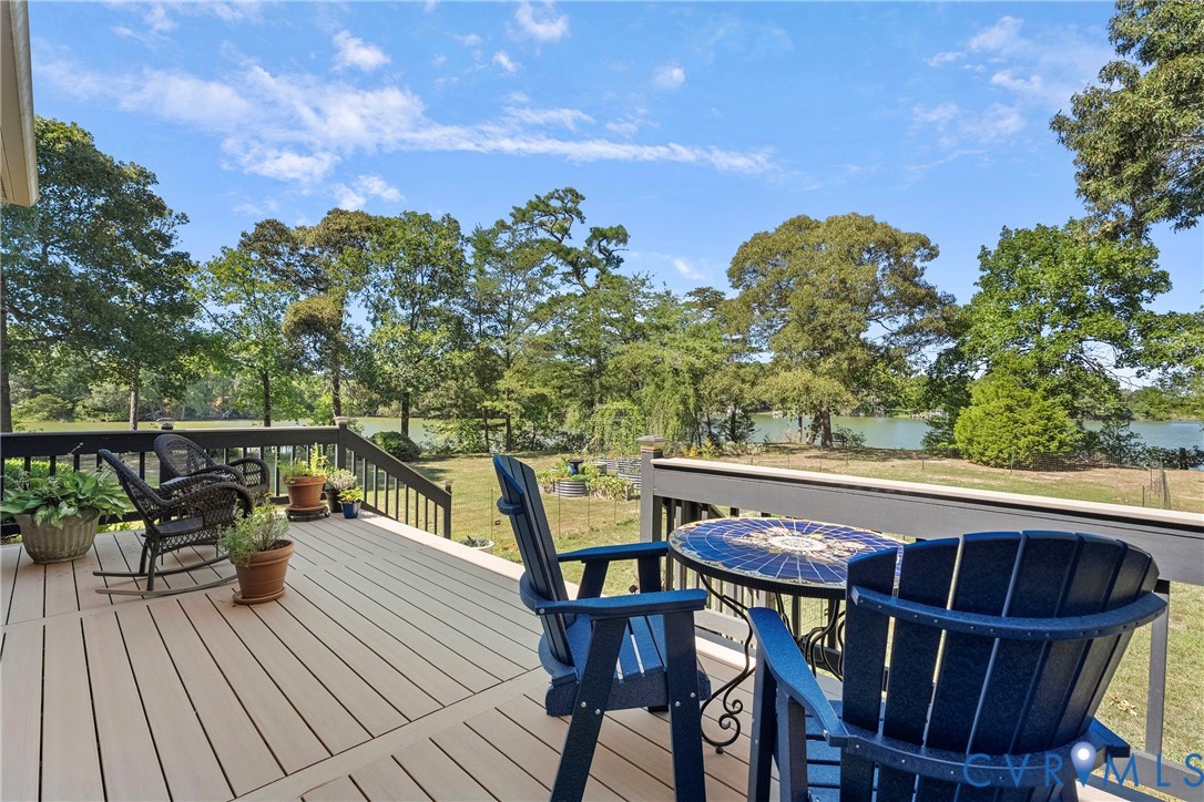 Spacious outdoor deck with composite decking, dark wood railings, and expansive water frontage