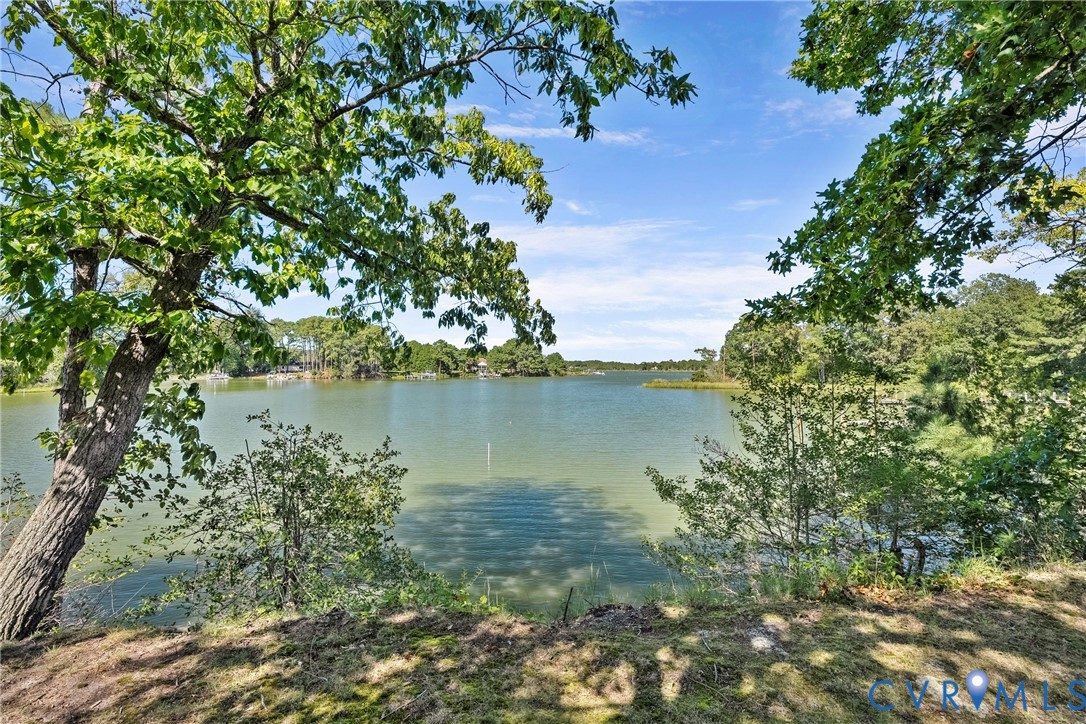 Expansive waterfront property featuring a wide body of water and mature trees