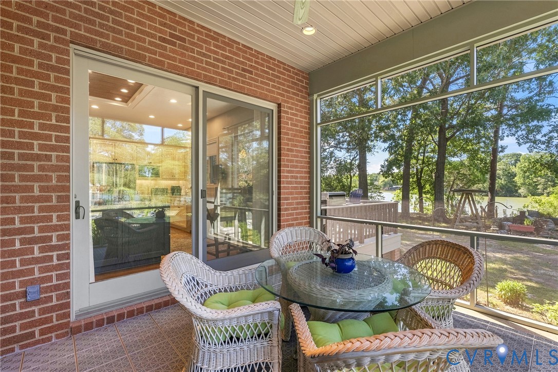 Screened-in porch with a tile floor, brick exterior, and a sliding glass door
