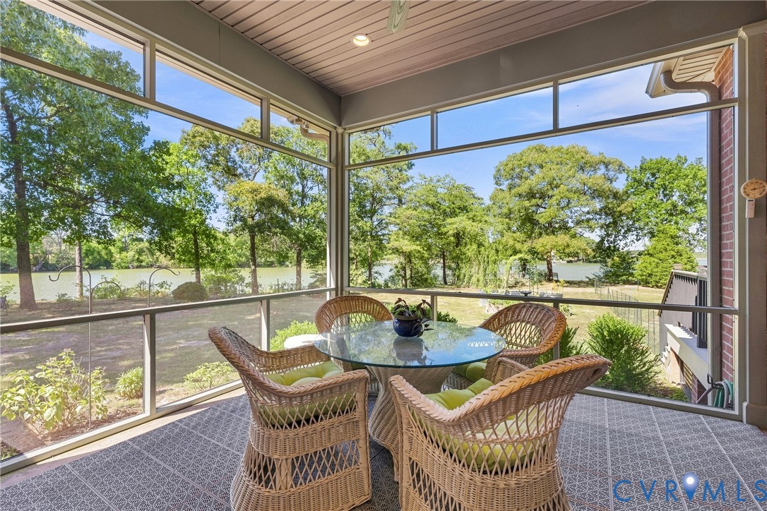 Screened porch with tiled flooring, integrated ceiling lighting, and expansive water frontage