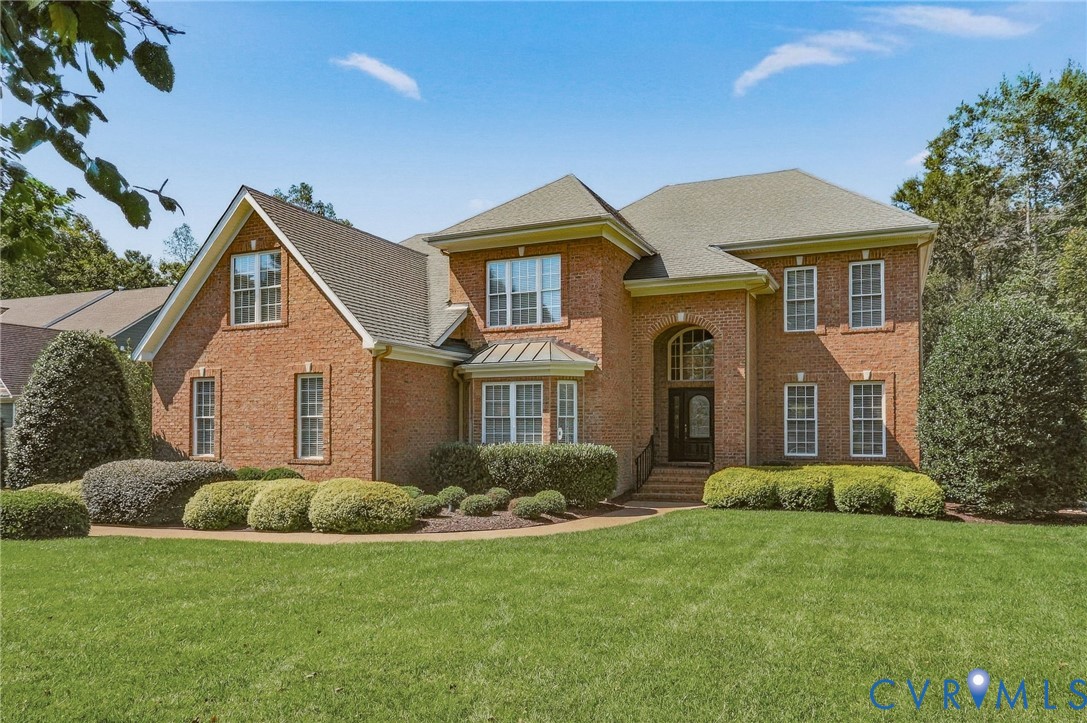Brick exterior with multiple gables, arched entry, bay window, and mature landscaping Brick exterior with multiple gables, arched entry, bay window, and mature landscaping