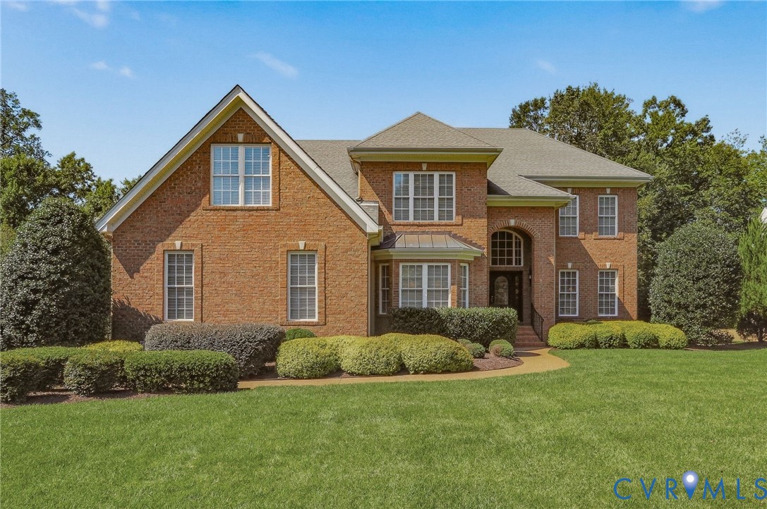 Brick exterior with multiple gables, extensive landscaping, and a broad lawn Brick exterior with multiple gables, extensive landscaping, and a broad lawn