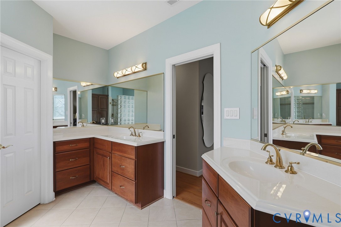 Double vanity featuring wood cabinetry and white countertops