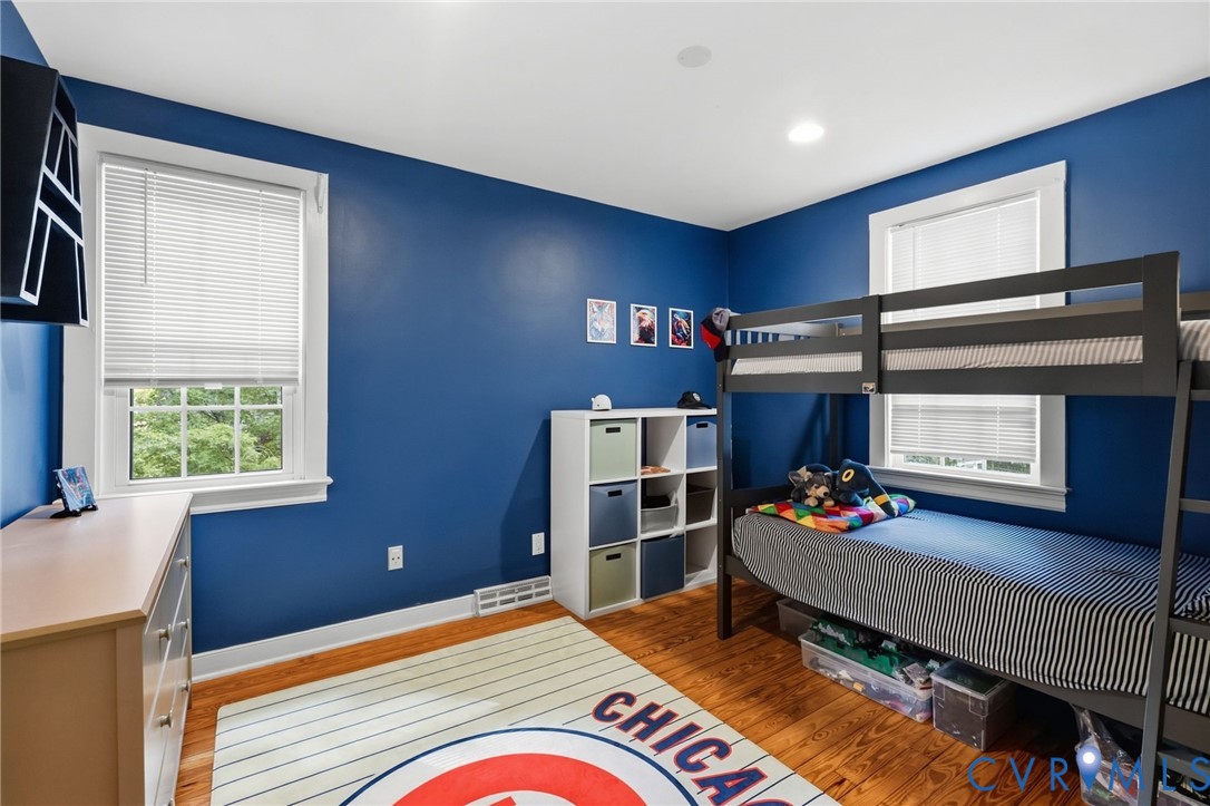 Hardwood flooring, recessed lighting, and dual windows with white trim