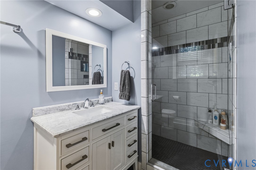 Vanity with a light-toned countertop, integrated sink, and dark hardware