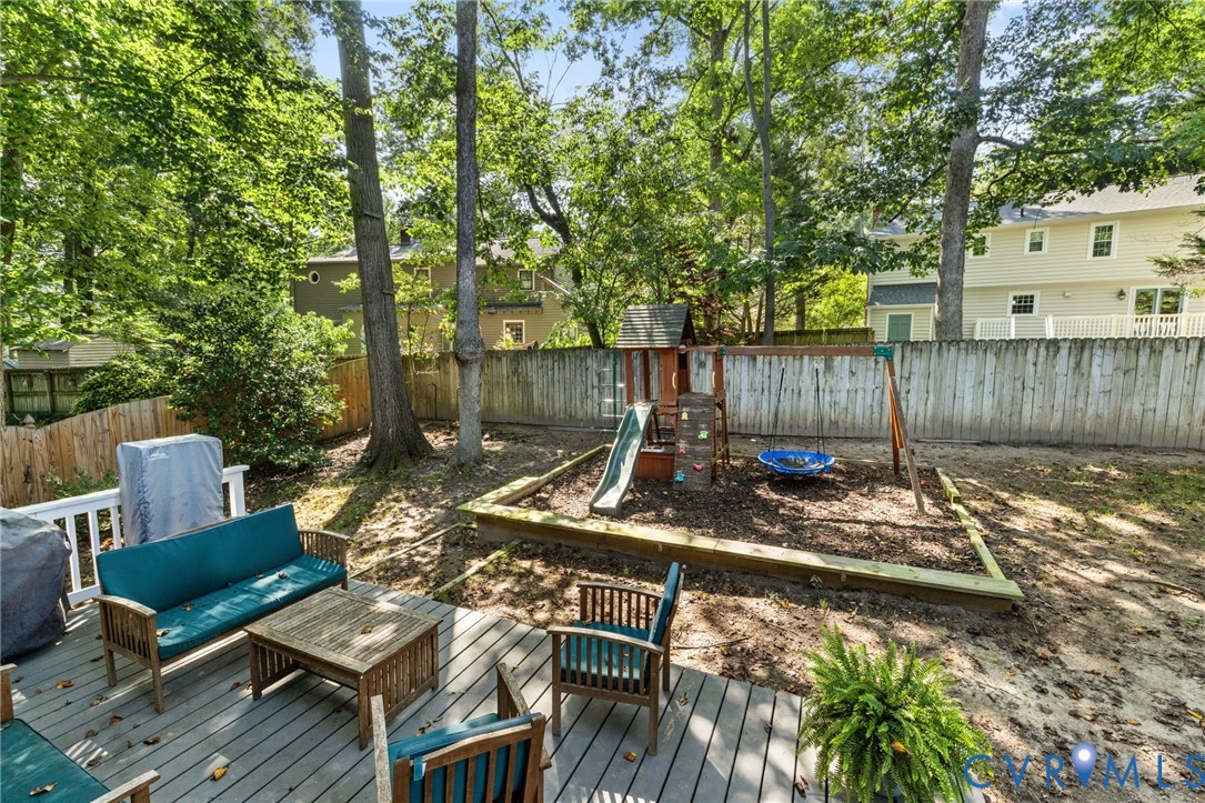 Expansive backyard featuring a wood privacy fence and mature trees