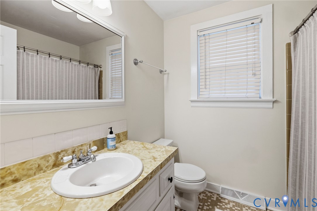 Warm-toned vanity with integrated sink, chrome fixtures, and a large framed mirror