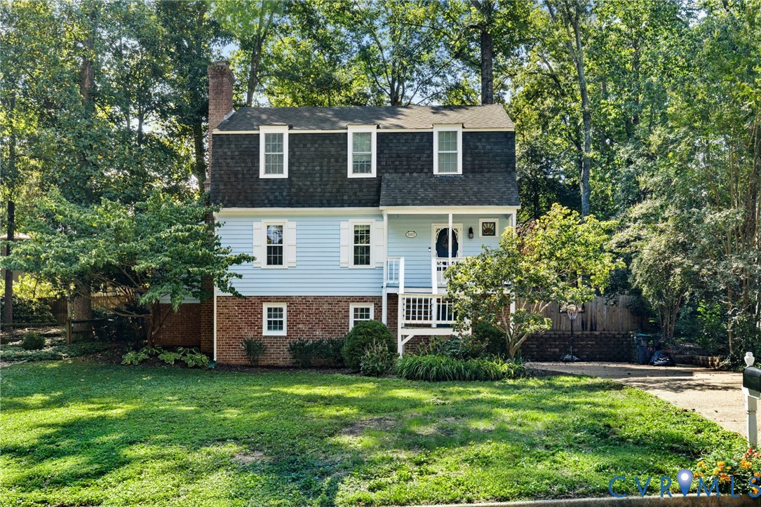Two-story residence with light blue siding and brick accents