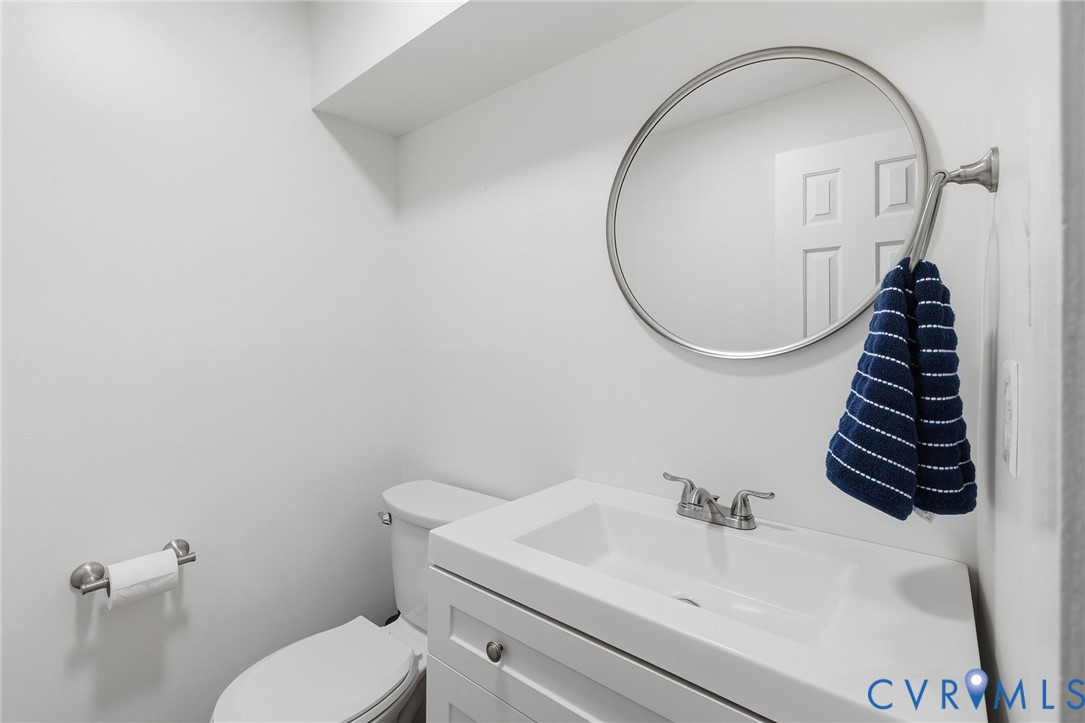 White vanity with an integrated rectangular sink and brushed nickel hardware