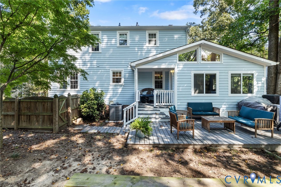 Expansive rear deck, light blue siding, white window trim, multiple large windows, and a raised covered porch
