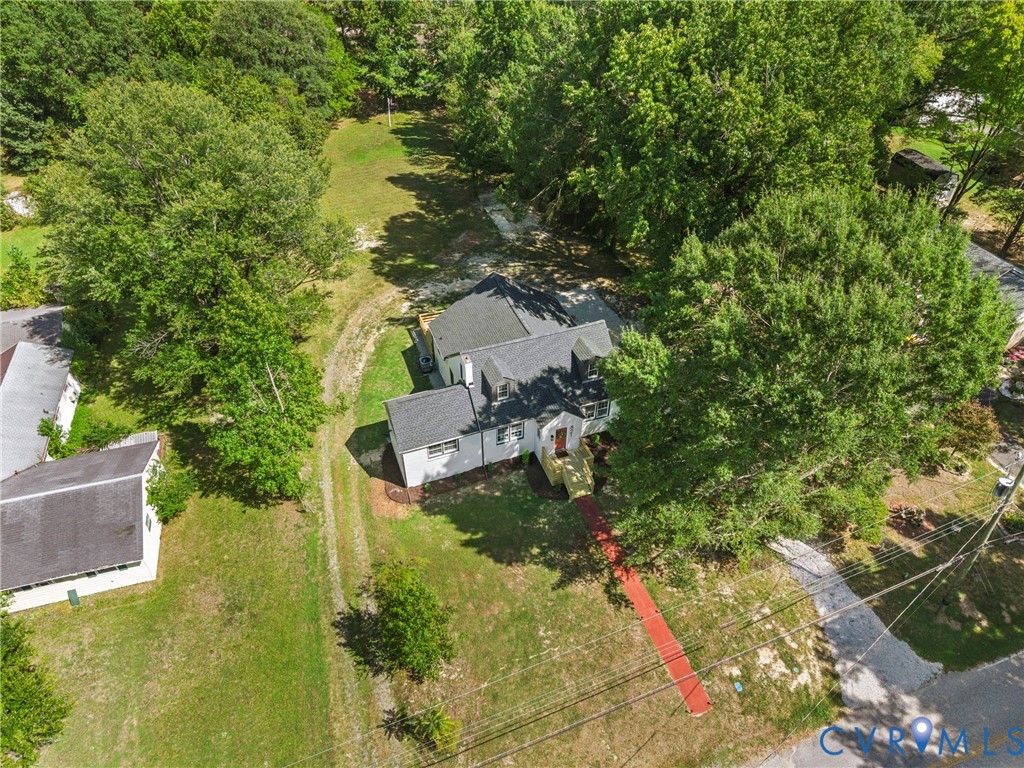 Expansive property with mature trees and a gravel driveway
