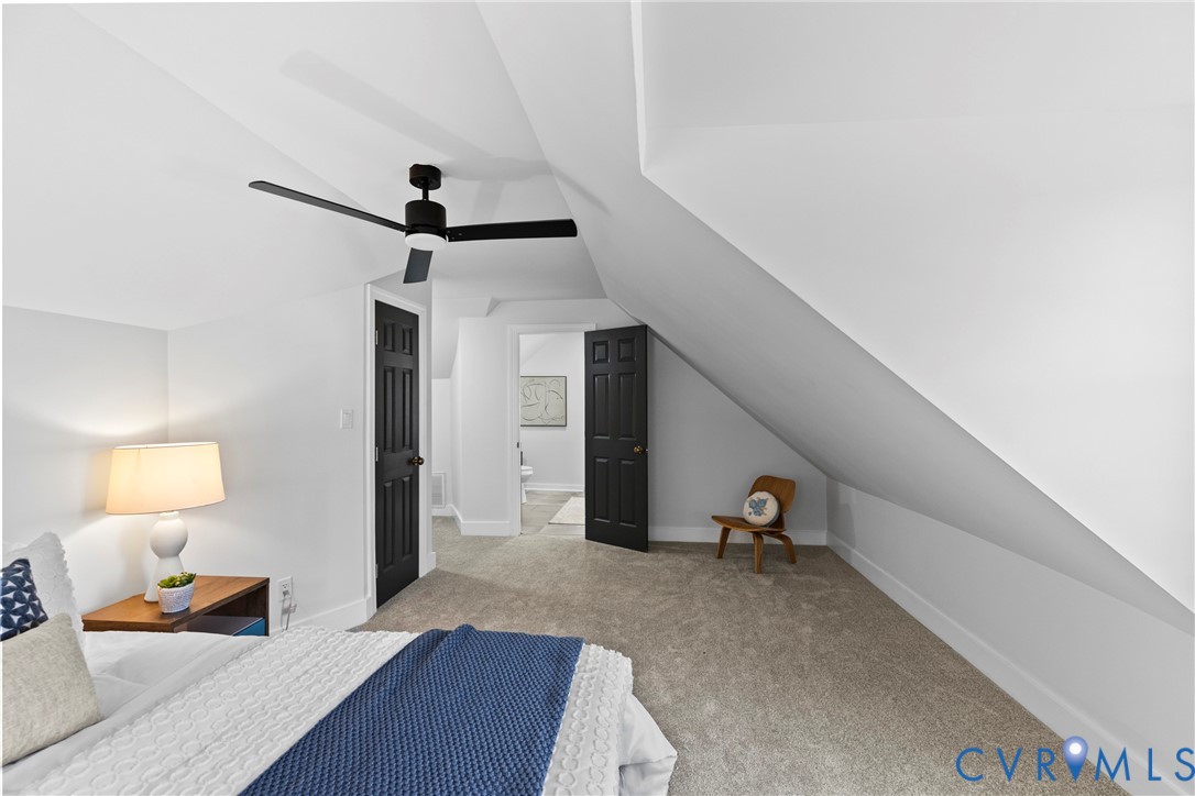Carpeted flooring, vaulted ceiling, and a modern ceiling fan