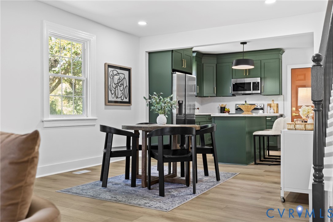 Kitchen featuring custom green cabinetry, stainless steel appliances, and white countertops