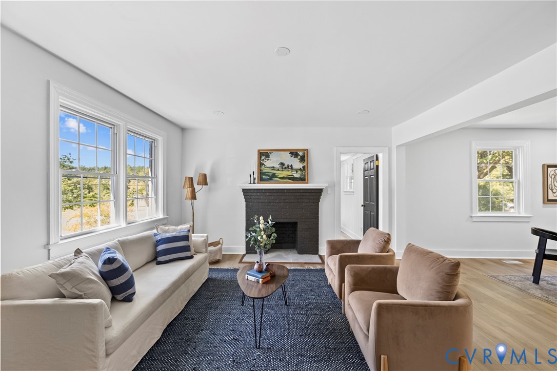 Living area featuring a dark brick fireplace, recessed lighting, and wood-finish flooring
