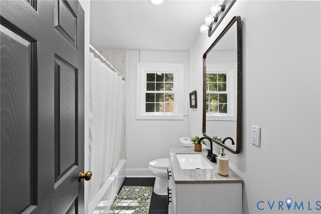 White vanity with a rectangular undermount sink, dark-finish faucet, and a wall-mounted mirror