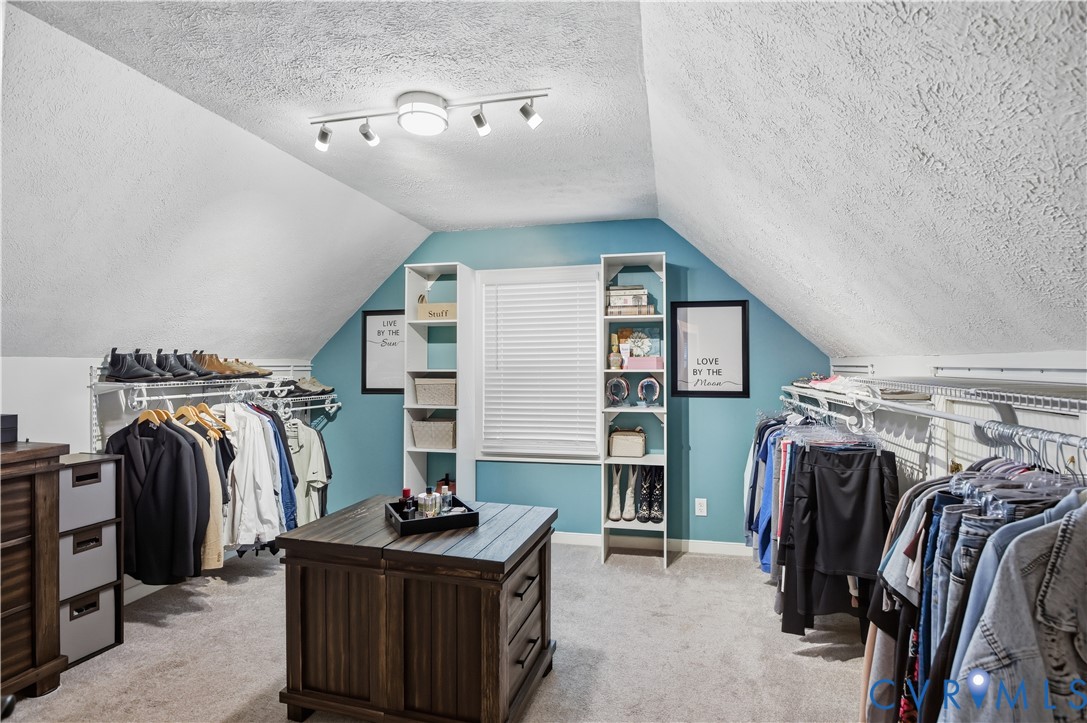 Custom built-in shelving, track lighting, and a central wood-finish island