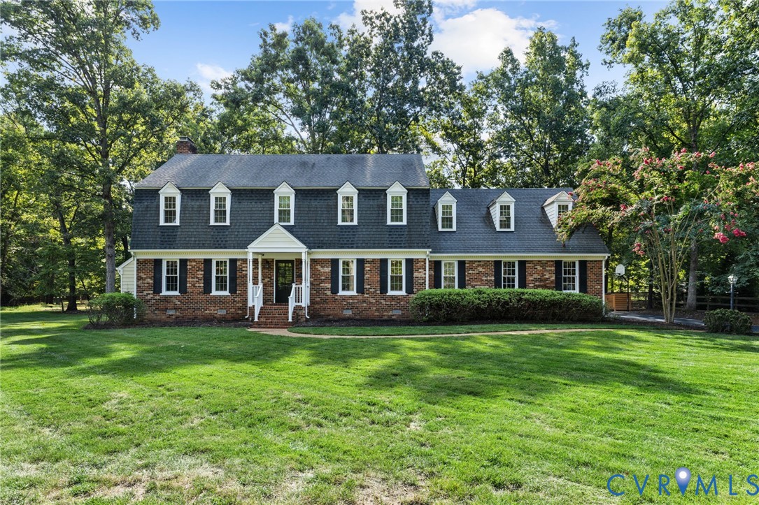 Traditional brick exterior with black shutters, white trim, and a prominent front portico