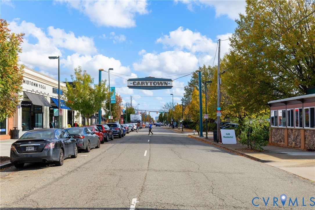 Vibrant street scene featuring commercial storefronts, mature street trees with autumn foliage, and a prominent "CARYTOWN" street sign