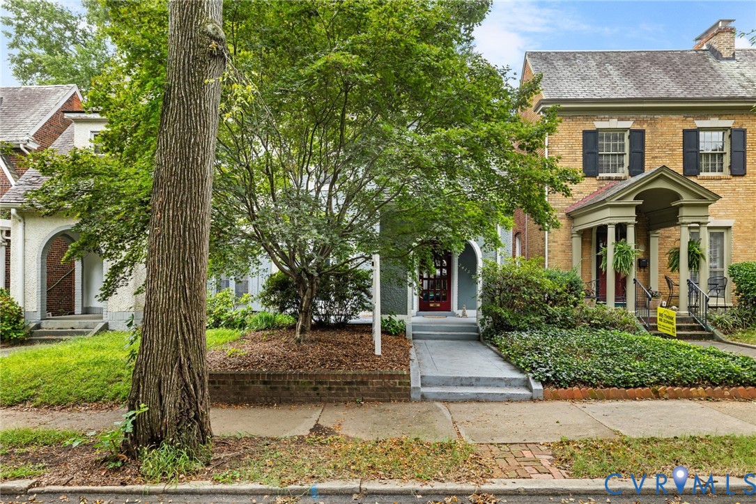 Brick exterior with black window shutters and a covered porch entry