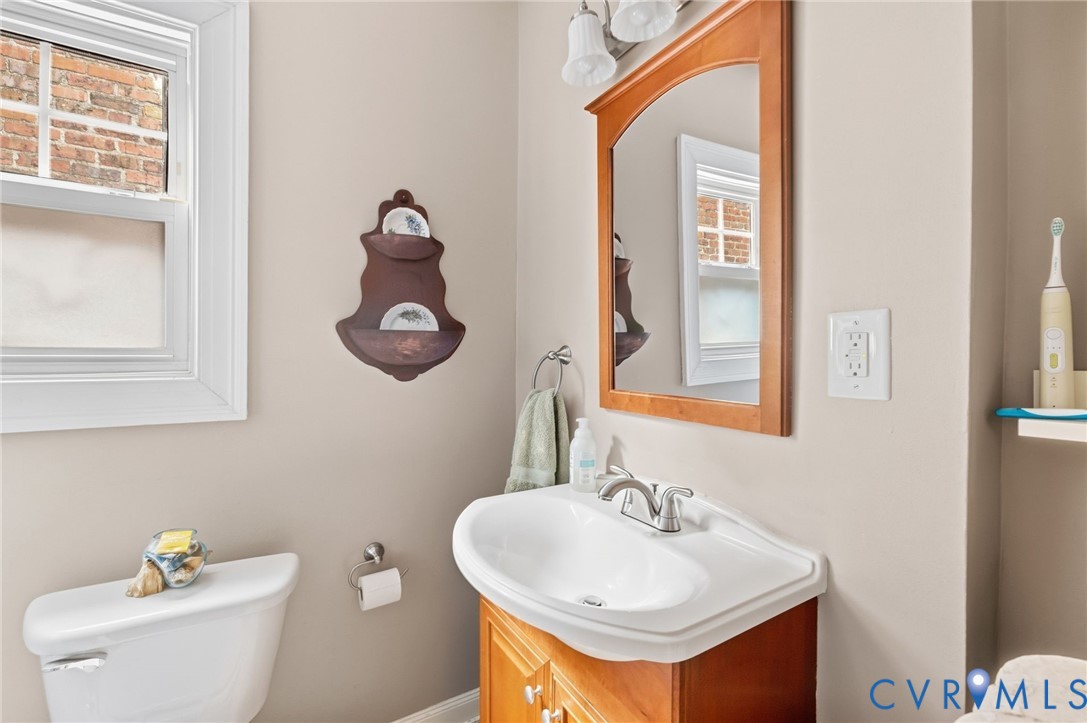 Integrated vanity with a white ceramic sink, chrome-finish faucet, and wood-finish cabinetry