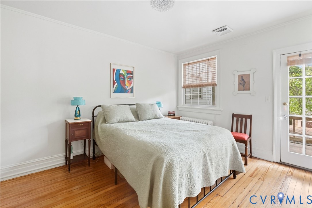 Hardwood flooring, painted white walls, white trim, glass-paned door, and a single window with blinds