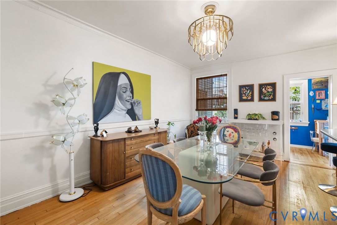 Hardwood flooring throughout, crown molding, and a decorative fireplace with a mantle