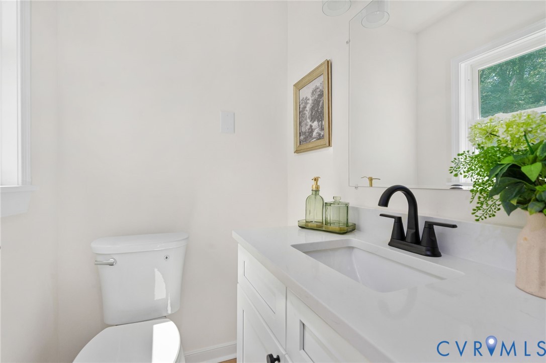 White vanity with an integrated rectangular sink, matte black faucet, and a large mirror