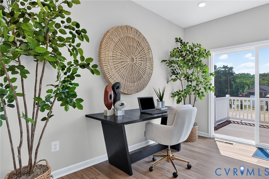 Recessed lighting, light-toned wall paint, wood-finish flooring, sliding glass door, and exterior decking with white railing