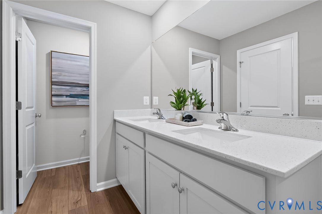 Dual vanity with undermount sinks, white cabinetry, and a full-width mirror