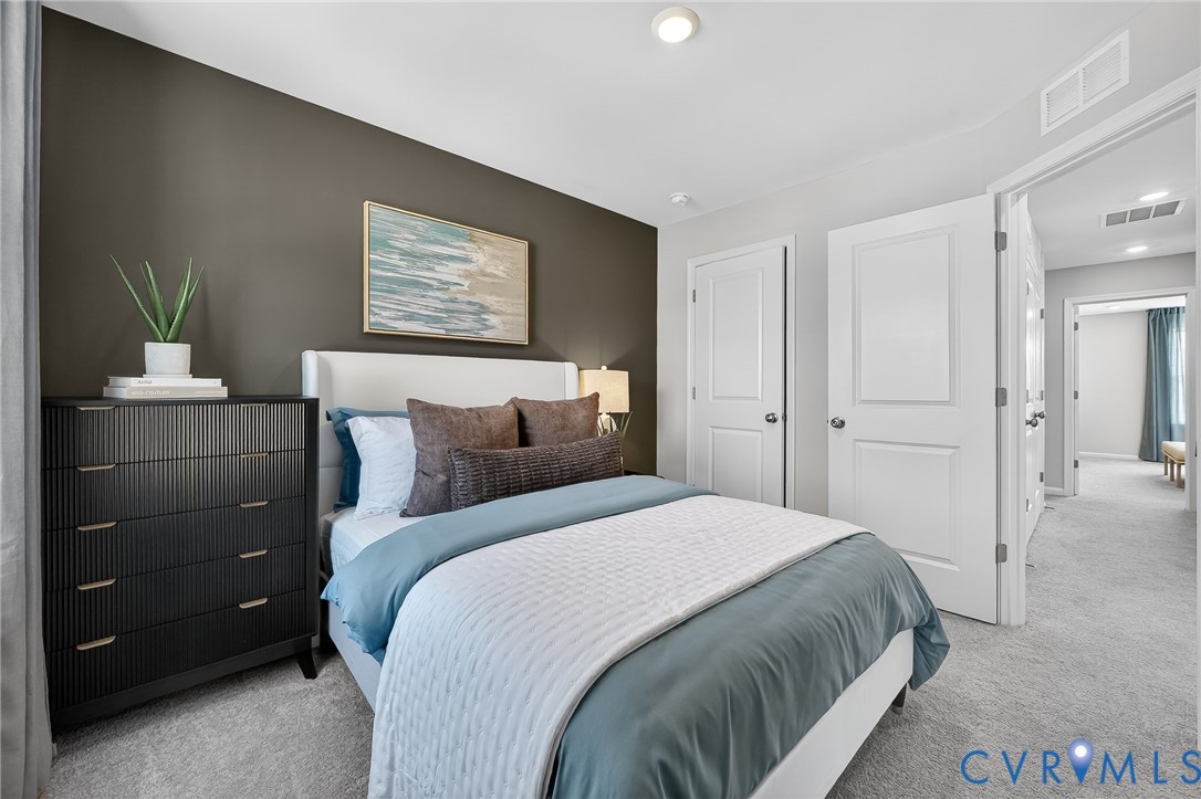 Neutral-toned walls with a contrasting accent wall, recessed ceiling lighting, and light-colored carpeting