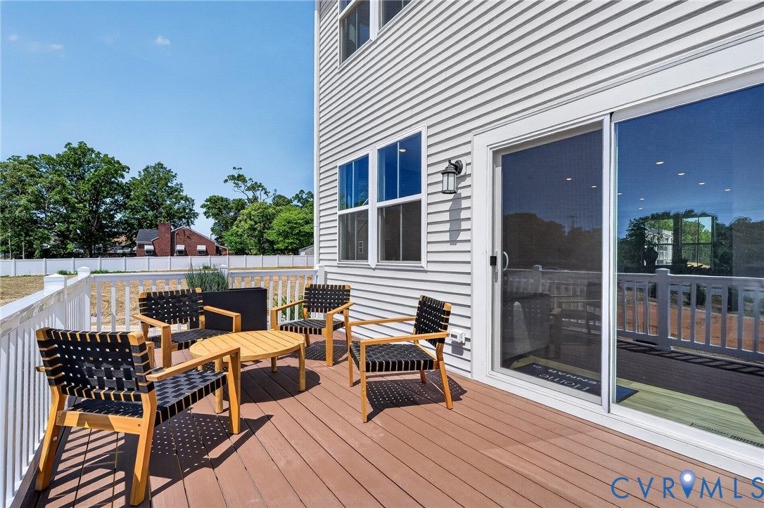 Spacious outdoor deck with composite flooring, white railing, and a sliding glass door