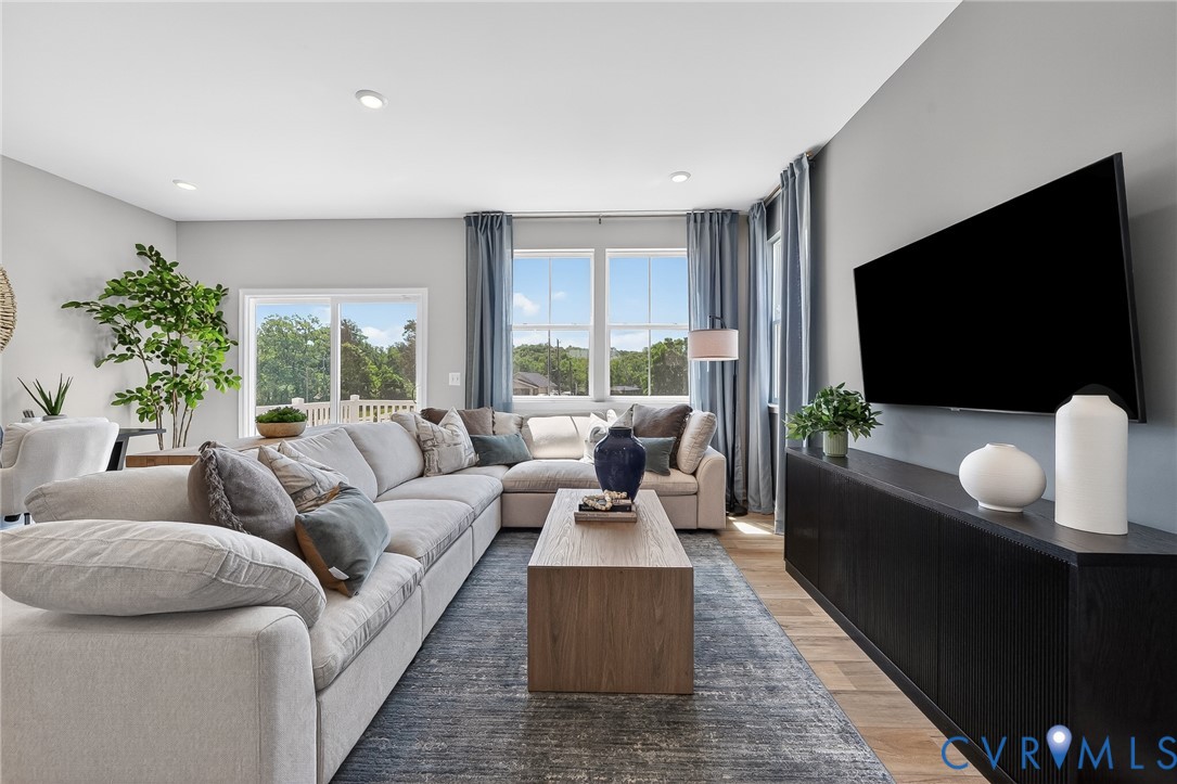 Recessed lighting, wood-finish flooring, and large windows with transom details
