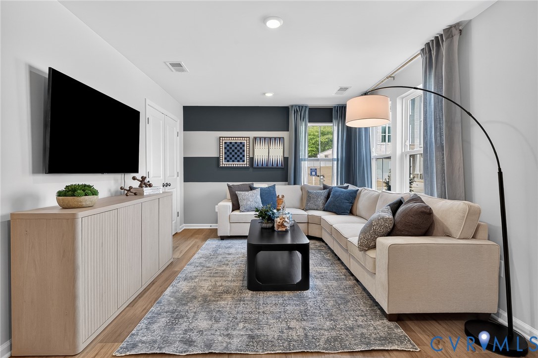 Recessed lighting, wood-finish flooring, and natural light from large windows