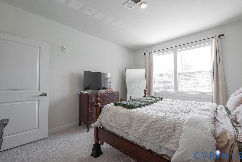 Light gray walls, white trim, and light-colored carpeting