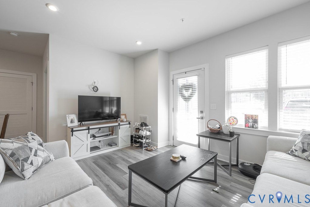 Recessed ceiling lighting, wood-finish flooring, multiple windows, and a glass-paneled exterior door Recessed ceiling lighting, wood-finish flooring, multiple windows, and a glass-paneled exterior door