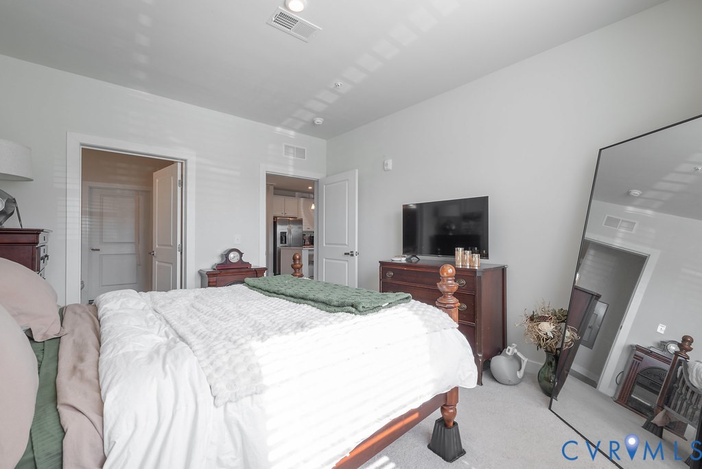 Recessed lighting, light-toned walls, and carpeted flooring