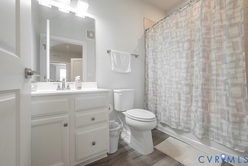 White vanity with a single basin sink, chrome faucet, and integrated mirror