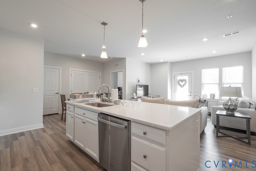 Kitchen island with white cabinetry and integrated stainless steel dishwasher Kitchen island with white cabinetry and integrated stainless steel dishwasher