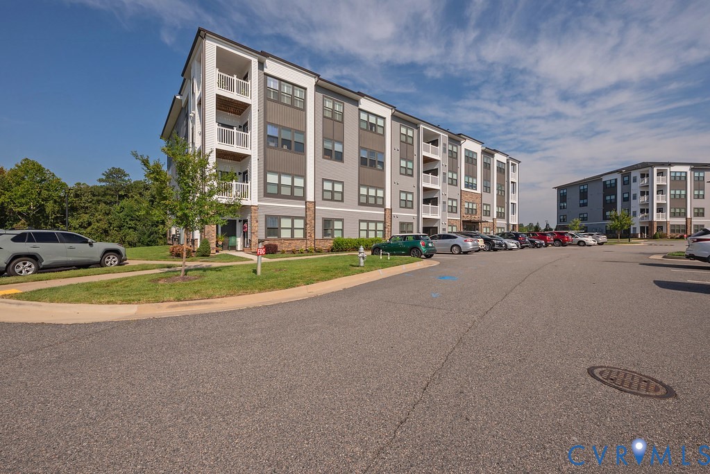 Contemporary apartment building with balconies, multi-tone siding, and stone accents