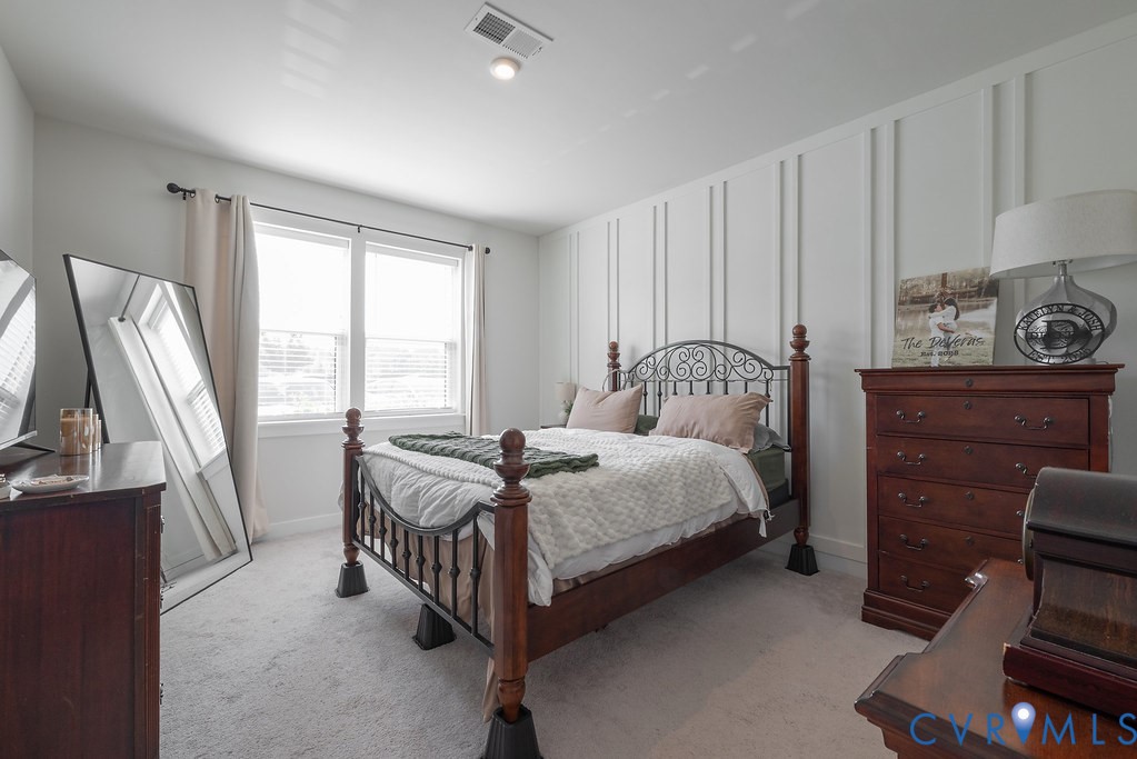 Carpeted room featuring a decorative accent wall, recessed lighting, and dual windows with blinds