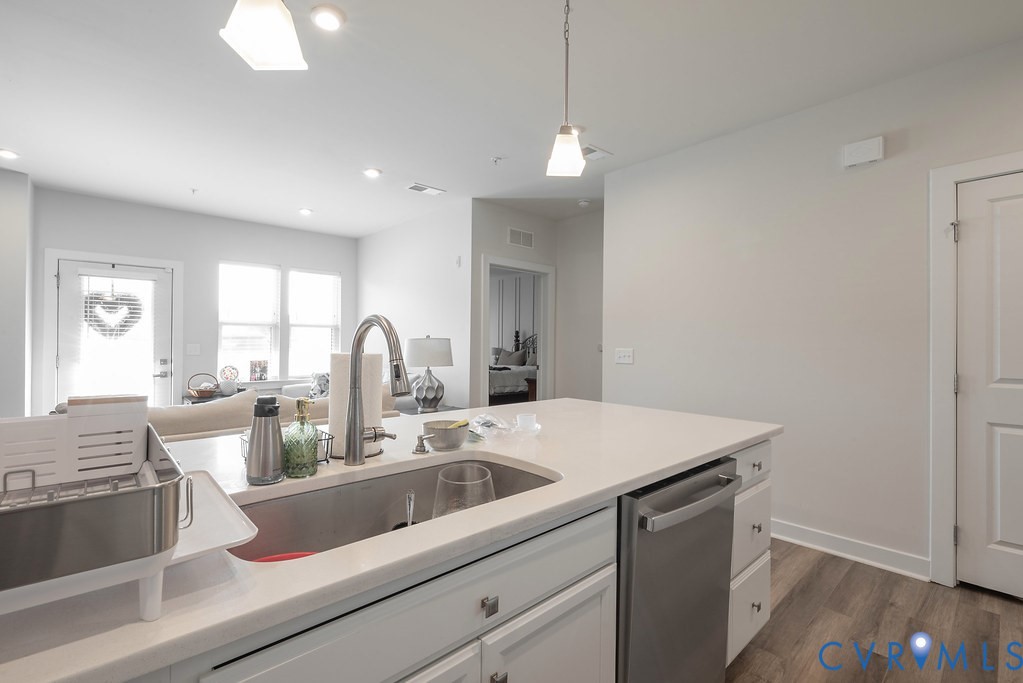 Kitchen island with an undermount sink, gooseneck faucet, and integrated stainless steel dishwasher