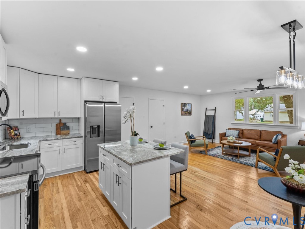 Open concept living area featuring wood-finish flooring, recessed lighting, and a ceiling fan