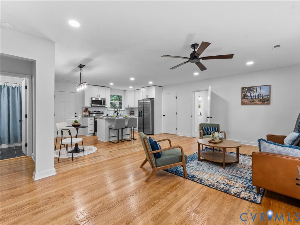 Wood-finish flooring, recessed lighting, and a ceiling fan Wood-finish flooring, recessed lighting, and a ceiling fan