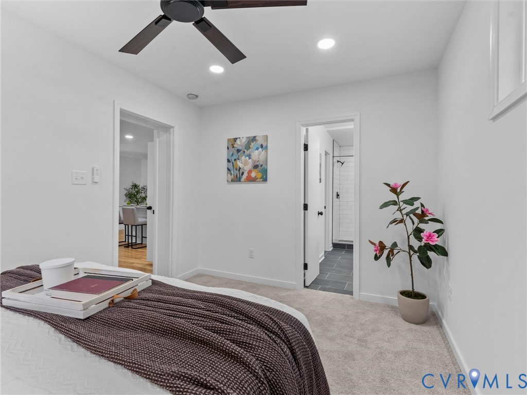Recessed lighting, ceiling fan with dark wood-finish blades, light-colored carpet flooring, white walls, and dark-toned door hardware