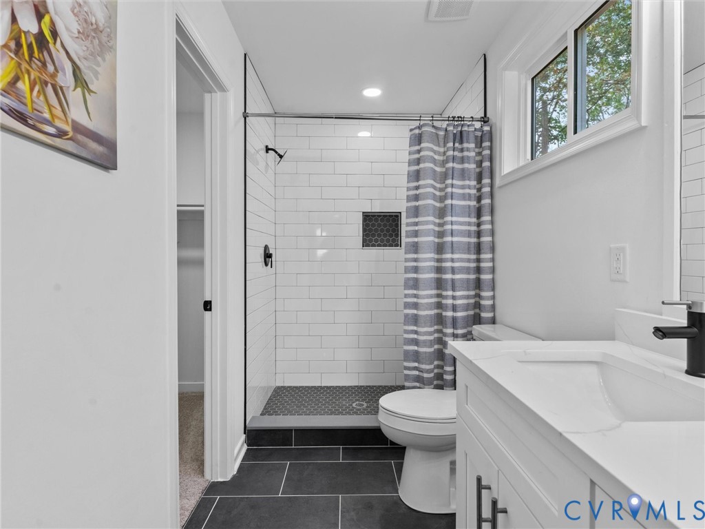 White subway tile shower with a dark tile base and accent niche