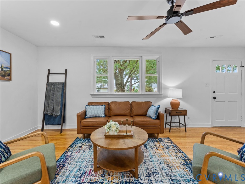 White walls, recessed lighting, wood-finish flooring, and a ceiling fan with wood-finish blades White walls, recessed lighting, wood-finish flooring, and a ceiling fan with wood-finish blades