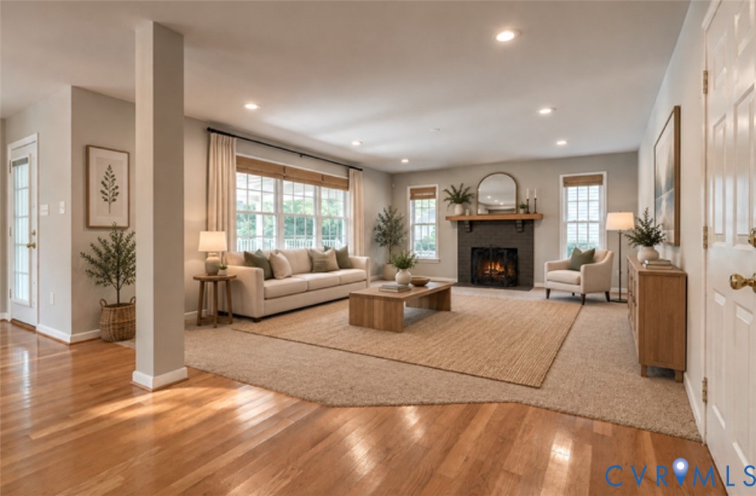 Recessed lighting, wood-finish flooring, a fireplace with a stone surround, and multiple windows