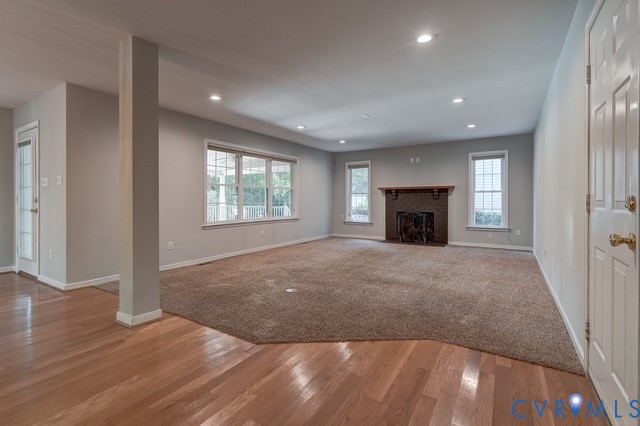 Spacious living room with wood burning fireplace, beautifully kept carpet for added warmth