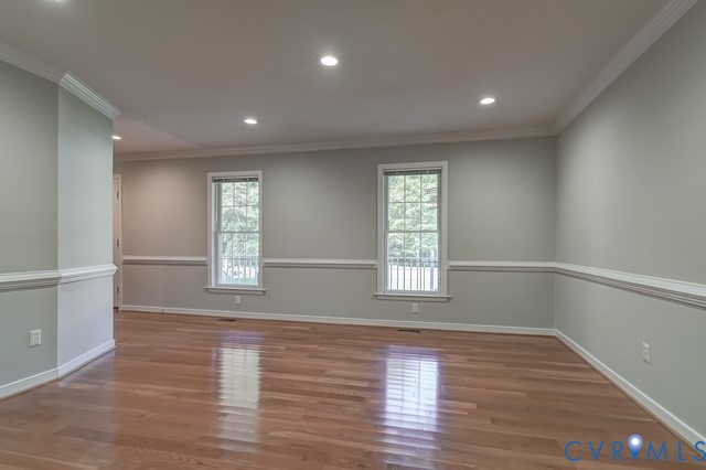 Recessed lighting, wood-finish flooring, two windows, crown molding, and chair rail detailing