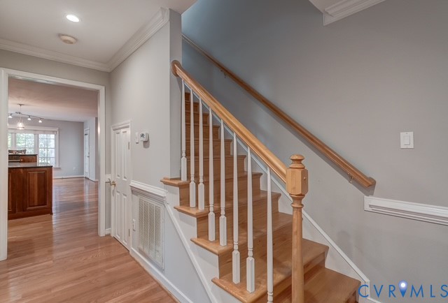 Hardwood flooring and staircase with wood railing and white balusters